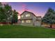 Spacious backyard featuring a well-maintained lawn, mature trees, and the back exterior of the house at 14910 Williams St, Thornton, CO 80602