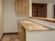 Basement wet bar area with wood cabinets, stone countertop, and tile flooring at 14910 Williams St, Thornton, CO 80602