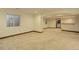 Large, open basement area with light-colored walls and carpet, featuring windows and an open doorway at 14910 Williams St, Thornton, CO 80602