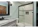 Remodeled bathroom with walk-in shower, white vanity, granite counters, and modern fixtures at 14910 Williams St, Thornton, CO 80602