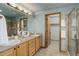 Bathroom featuring double sinks, spacious vanity, shower, and access to a walk-in closet at 14910 Williams St, Thornton, CO 80602