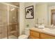 Bathroom featuring a glass enclosed shower, oak vanity, and neutral wall decor at 14910 Williams St, Thornton, CO 80602