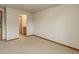 Bedroom with ensuite bathroom featuring neutral carpet and base trim at 14910 Williams St, Thornton, CO 80602