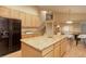 Bright kitchen with light wood cabinets, granite countertops, island, and view of the staircase and dining area at 14910 Williams St, Thornton, CO 80602