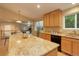 Kitchen with a view of the dining area, natural wood cabinets, granite countertops, and black appliances at 14910 Williams St, Thornton, CO 80602