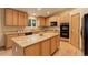 A spacious kitchen featuring light wood cabinets, granite countertops, an island, and modern appliances at 14910 Williams St, Thornton, CO 80602