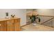 Carpeted landing featuring decorative railing, wooden storage cabinet, and a potted plant at 14910 Williams St, Thornton, CO 80602