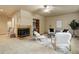 A cozy living room featuring a stone fireplace, built-in shelving, and neutral decor and carpet at 14910 Williams St, Thornton, CO 80602