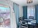Dining area with a wood table set for four, with a sliding glass door and blue curtains at 413 Jamaica St, Aurora, CO 80010