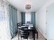 Bright dining room featuring a dark wood table and chairs set, stylish light fixture, and large windows with curtains at 413 Jamaica St, Aurora, CO 80010