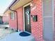 Close-up of brick home with decorative front door and adjacent window at 413 Jamaica St, Aurora, CO 80010
