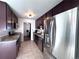 Bright kitchen featuring stainless steel appliances, granite countertops, tile floor, and dark cabinets at 413 Jamaica St, Aurora, CO 80010