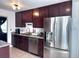 Kitchen featuring stainless steel appliances, granite countertops, tile floor, and dark cabinets at 413 Jamaica St, Aurora, CO 80010