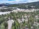 The property is located in a heavily wooded area with a long driveway, and distant mountain views at 9299 William Cody Dr, Evergreen, CO 80439
