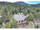 The back of the property features a large wooden deck with black metal railings, and a ground-level patio area at 9299 William Cody Dr, Evergreen, CO 80439
