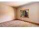 The bedroom has neutral carpet and walls, and a window showcasing an outdoor view at 9299 William Cody Dr, Evergreen, CO 80439