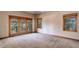 Spacious bedroom with carpet and views of nature through windows and sliding glass doors at 9299 William Cody Dr, Evergreen, CO 80439