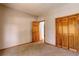 A bedroom view shows plush carpet, wood trim and a closet with bi-fold doors at 9299 William Cody Dr, Evergreen, CO 80439