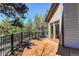 Large deck features brown wood flooring with a view of mature trees and blue sky at 9299 William Cody Dr, Evergreen, CO 80439