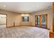 Spacious living room with bright lighting, sliding glass doors, and a view of nature at 9299 William Cody Dr, Evergreen, CO 80439