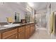Bathroom with double vanity, large mirror, enclosed shower, and wooden cabinets at 9318 Las Ramblas Ct # R, Parker, CO 80134