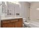 Well-lit bathroom featuring a vanity with wooden cabinets, mirror, and shower-tub combo at 9318 Las Ramblas Ct # R, Parker, CO 80134