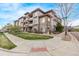 Attractive three-story condo building with stone accents, balconies, and well-maintained landscaping on a sunny day at 9318 Las Ramblas Ct # R, Parker, CO 80134