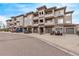 View of a condo building exterior featuring multiple units, private balconies, and attached garages along a quiet street at 9318 Las Ramblas Ct # R, Parker, CO 80134