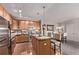 Well-equipped kitchen with stainless steel appliances, wood cabinets, and an island with bar seating open to the living space at 9318 Las Ramblas Ct # R, Parker, CO 80134