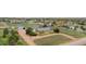 Aerial view of a property featuring a brick home, a detached garage, mature trees, and a winding driveway at 15020 Harrison St, Brighton, CO 80602