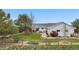 Landscaped backyard featuring a lawn, fence, mature trees, and an outdoor seating area at 15020 Harrison St, Brighton, CO 80602