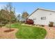 Beautifully landscaped backyard with lush green lawn, brick and stone accents and mature trees at 15020 Harrison St, Brighton, CO 80602