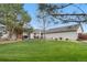 Expansive backyard with well-maintained lawn, mature trees, and outdoor deck/patio at 15020 Harrison St, Brighton, CO 80602