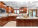 Well-lit kitchen featuring wooden cabinets, granite countertops, stainless steel appliances, and a functional island at 15020 Harrison St, Brighton, CO 80602
