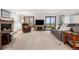 Bright living room with plush seating, a brick fireplace, large windows, and neutral-toned carpet at 15020 Harrison St, Brighton, CO 80602