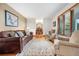 Spacious living room featuring hardwood floors, a leather sofa, and large windows at 15020 Harrison St, Brighton, CO 80602