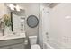 Well-lit bathroom with a white vanity, shower-tub combo, decorative mirror, and neutral color scheme at 3418 Belleville Ridge Rd, Elizabeth, CO 80107