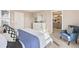 Bright bedroom with blue accents, a white dresser, a bed with a decorative throw, and an ensuite bathroom at 3418 Belleville Ridge Rd, Elizabeth, CO 80107