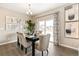 Bright dining room featuring a dark wood table, upholstered chairs, modern light fixture, and sliding glass doors at 3418 Belleville Ridge Rd, Elizabeth, CO 80107