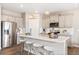 Bright kitchen boasts an island with seating, stainless steel appliances, and modern pendant lighting over white and gray cabinets at 3418 Belleville Ridge Rd, Elizabeth, CO 80107