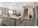 Spacious kitchen with a large island, stainless steel appliances, sleek cabinets, and hardwood floors leading to the stairs at 3418 Belleville Ridge Rd, Elizabeth, CO 80107