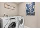 This laundry room is equipped with modern washer and dryer with wall art at 3418 Belleville Ridge Rd, Elizabeth, CO 80107