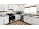 Kitchen featuring white cabinets, stainless steel appliances, and plenty of natural light at 10774 W 107Th Cir, Broomfield, CO 80021