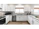 This modern kitchen offers white cabinets, stainless steel appliances, and a bright window at 10774 W 107Th Cir, Broomfield, CO 80021