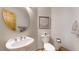 Modern powder room featuring a pedestal sink, round mirror, and decorative artwork at 9559 Brook Hill Ln, Lone Tree, CO 80124