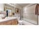 Bright bathroom featuring a shower over tub, vanity, and decorative lighting with a view into the bedroom at 9559 Brook Hill Ln, Lone Tree, CO 80124