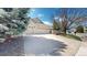 Charming front exterior with a well-maintained lawn, mature trees, and an extended driveway leading to a two-car garage at 9559 Brook Hill Ln, Lone Tree, CO 80124