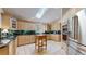 Well-lit kitchen featuring light wood cabinets, granite countertops, a skylight, stainless steel appliances and tiled floor at 9559 Brook Hill Ln, Lone Tree, CO 80124