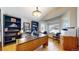 Bright home office with hardwood floors, built-in bookshelves, a large desk, and a sunny bay window at 9559 Brook Hill Ln, Lone Tree, CO 80124