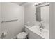 This charming powder room features a sleek, white sink and vanity with a modern faucet and a tile accent wall at 2620 Bellaire St, Denver, CO 80207